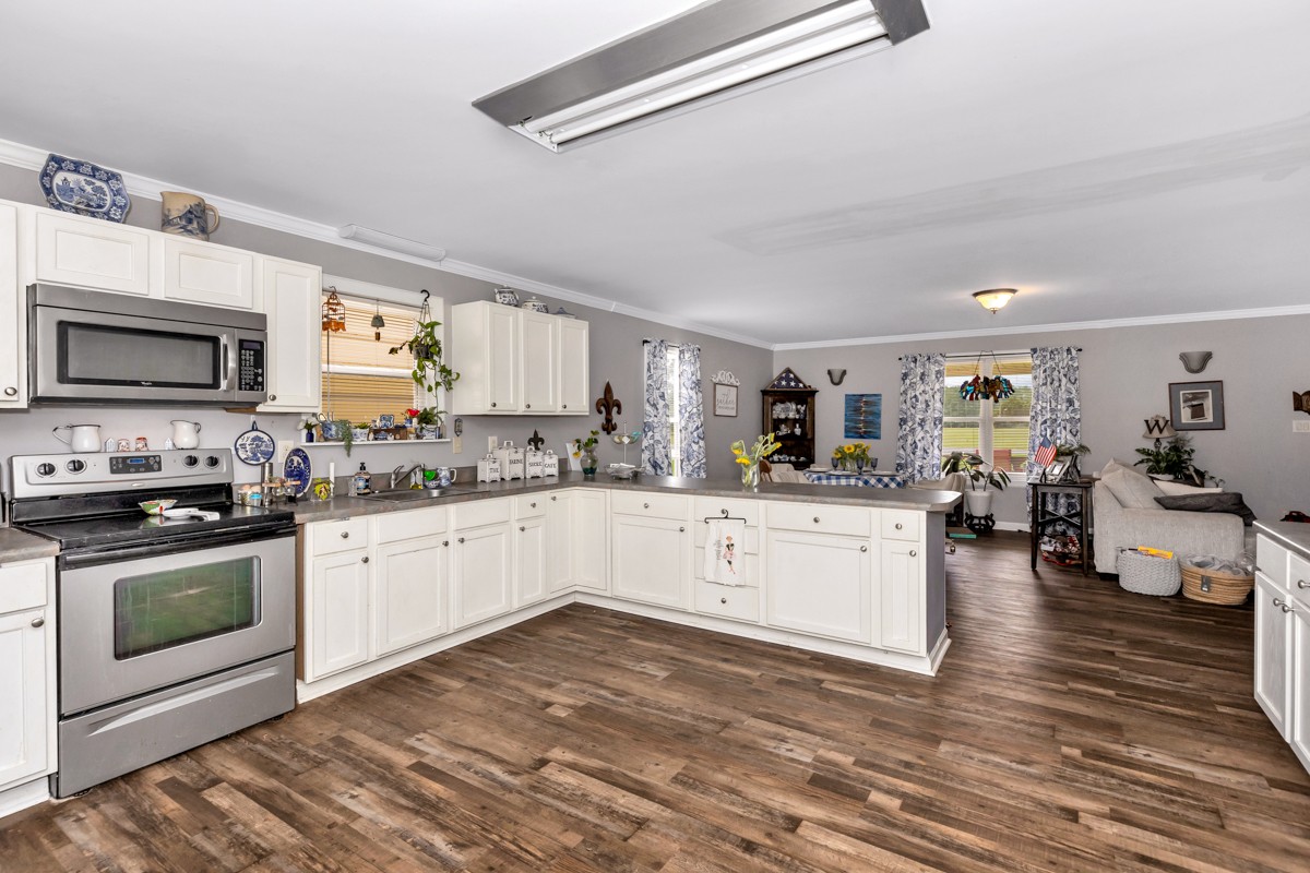 113 Elliot Road Ardmore, TN 38449 - Photo 10 of 25 a kitchen with stainless steel appliances granite countertop a stove top oven a sink dishwasher and a refrigerator with wooden floor