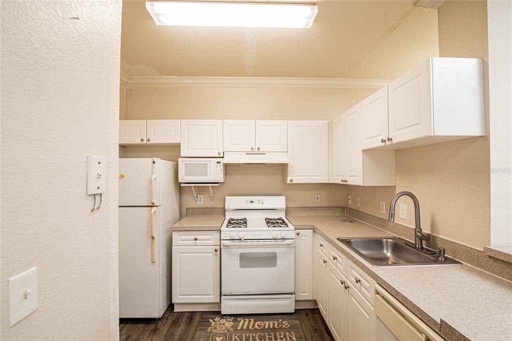 3391 South Kirkman Road, Unit 1216 Orlando, FL 32811 - Photo 9 of 33 a kitchen with a stove a sink and a refrigerator