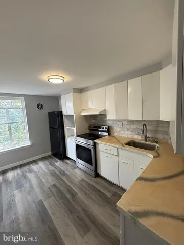 a kitchen with granite countertop a refrigerator and a sink