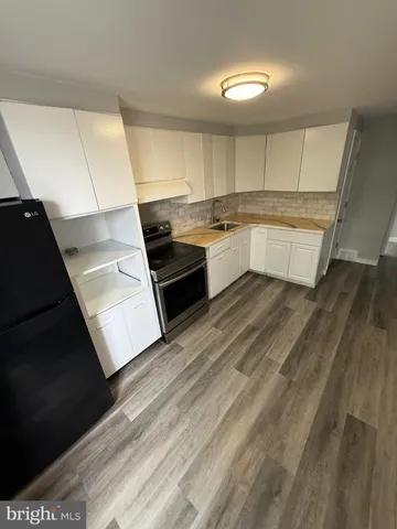 a large white kitchen with a stove a sink and dishwasher