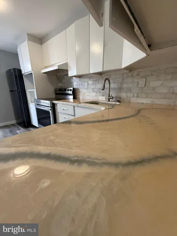 a kitchen with stainless steel appliances granite countertop a sink a stove and a refrigerator