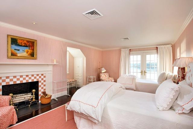 a bedroom with a bed a fireplace and a large window