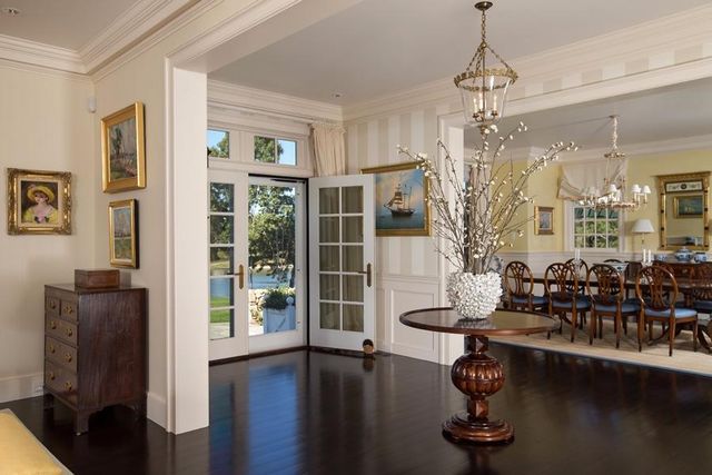 a room with lots of wooden furniture and floor to ceiling windows