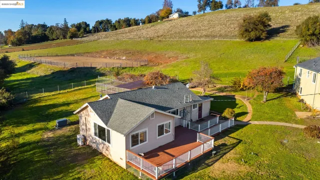 an aerial view of residential houses with outdoor space and ocean view