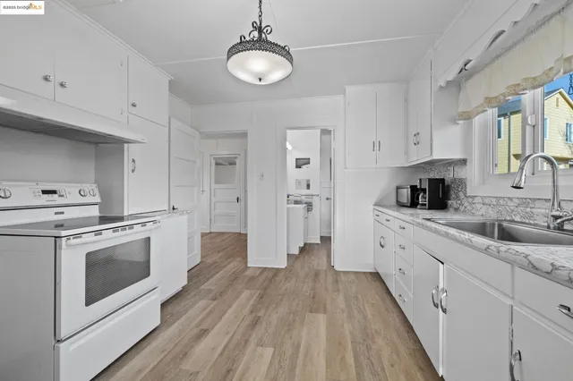 a kitchen with white cabinets stainless steel appliances and sink