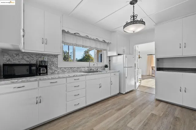 a kitchen with white cabinets and refrigerator