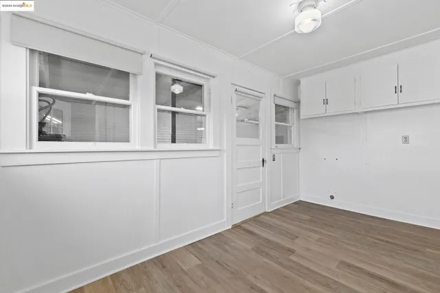 an empty room with wooden floor and cabinet