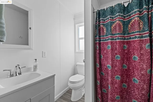 a bathroom with a toilet sink vanity and mirror