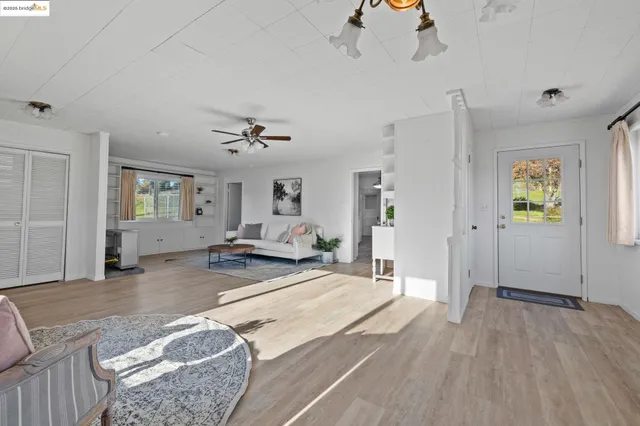 a view of a livingroom with wooden floor and a ceiling fan