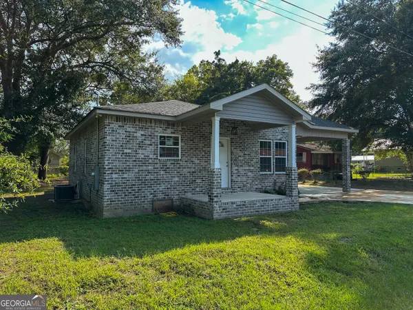 a front view of a house with a garden and yard