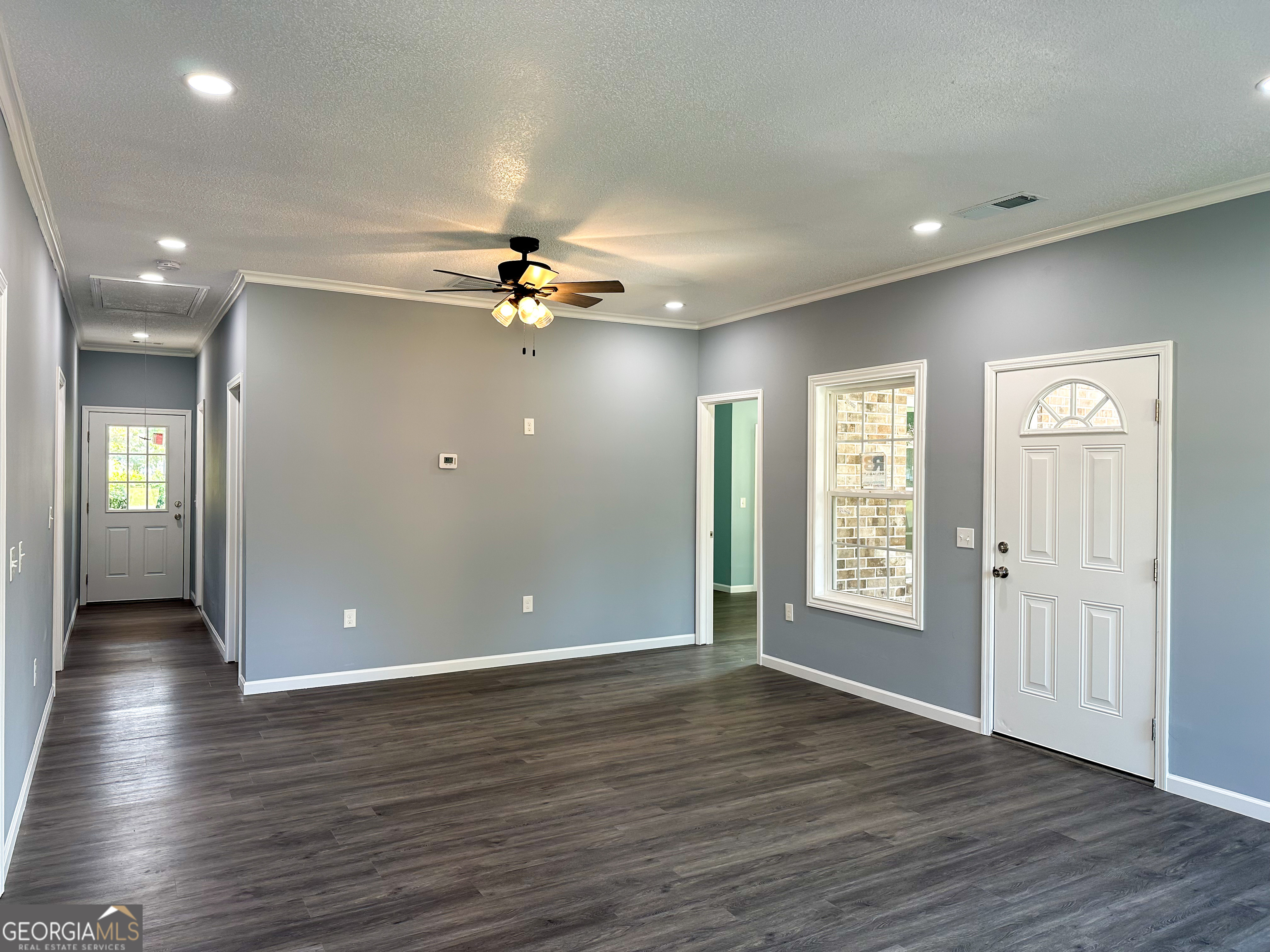 104 Robinson Street Byron, GA 31008 - Photo 10 of 11 an empty room with wooden floor and windows