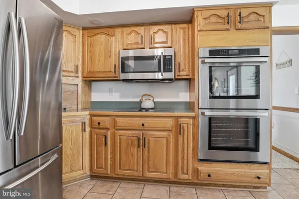 an open kitchen with granite countertop a stove dining table chairs and a large window
