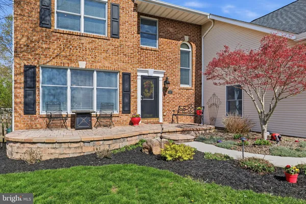 a front view of a house with yard and trees around