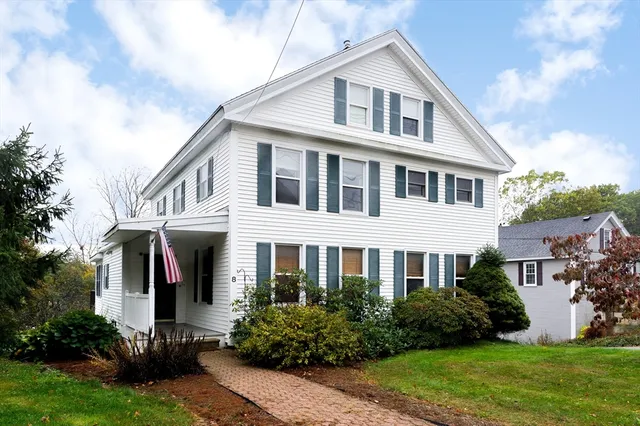 a front view of a house with porch and garden