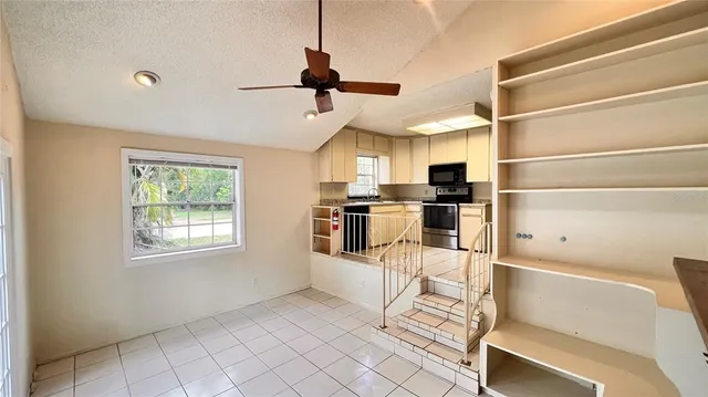 a kitchen with stainless steel appliances kitchen island granite countertop a refrigerator and microwave