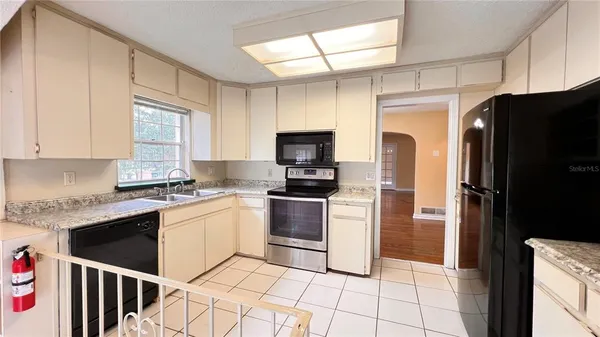 a kitchen with stainless steel appliances granite countertop a refrigerator stove and sink
