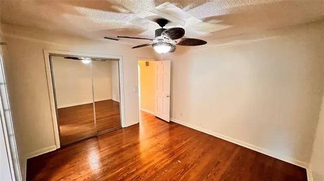 a view of an empty room with wooden floor