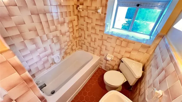 a bathroom with a toilet and a mirror