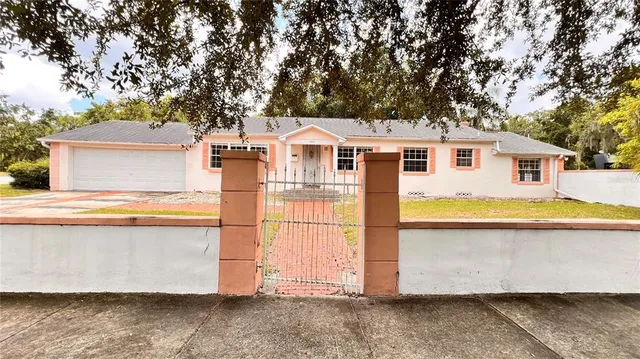 a view of a white house with a large pool and a yard
