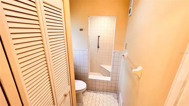 a white toilet sitting next to a shower