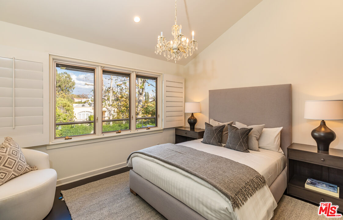 851 Glenmont Avenue Los Angeles, CA 90024 - Photo 18 of 26 a bedroom with a large bed and a chandelier