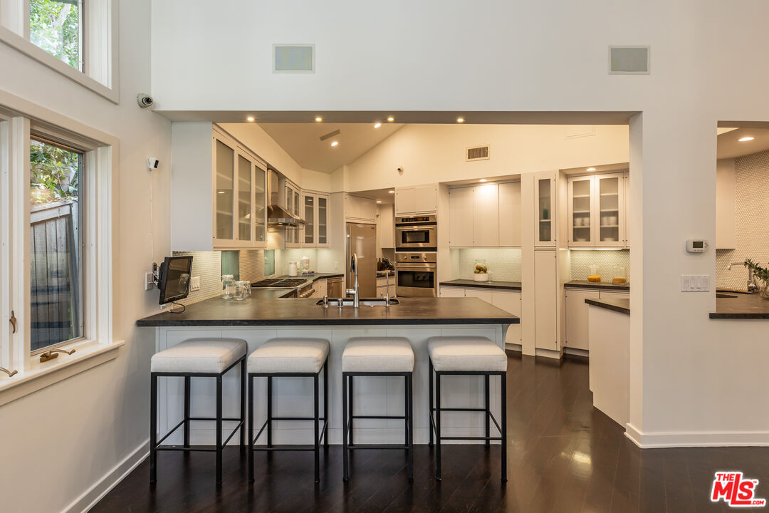 851 Glenmont Avenue Los Angeles, CA 90024 - Photo 8 of 26 a kitchen with stainless steel appliances granite countertop a dining table chairs and granite counter tops