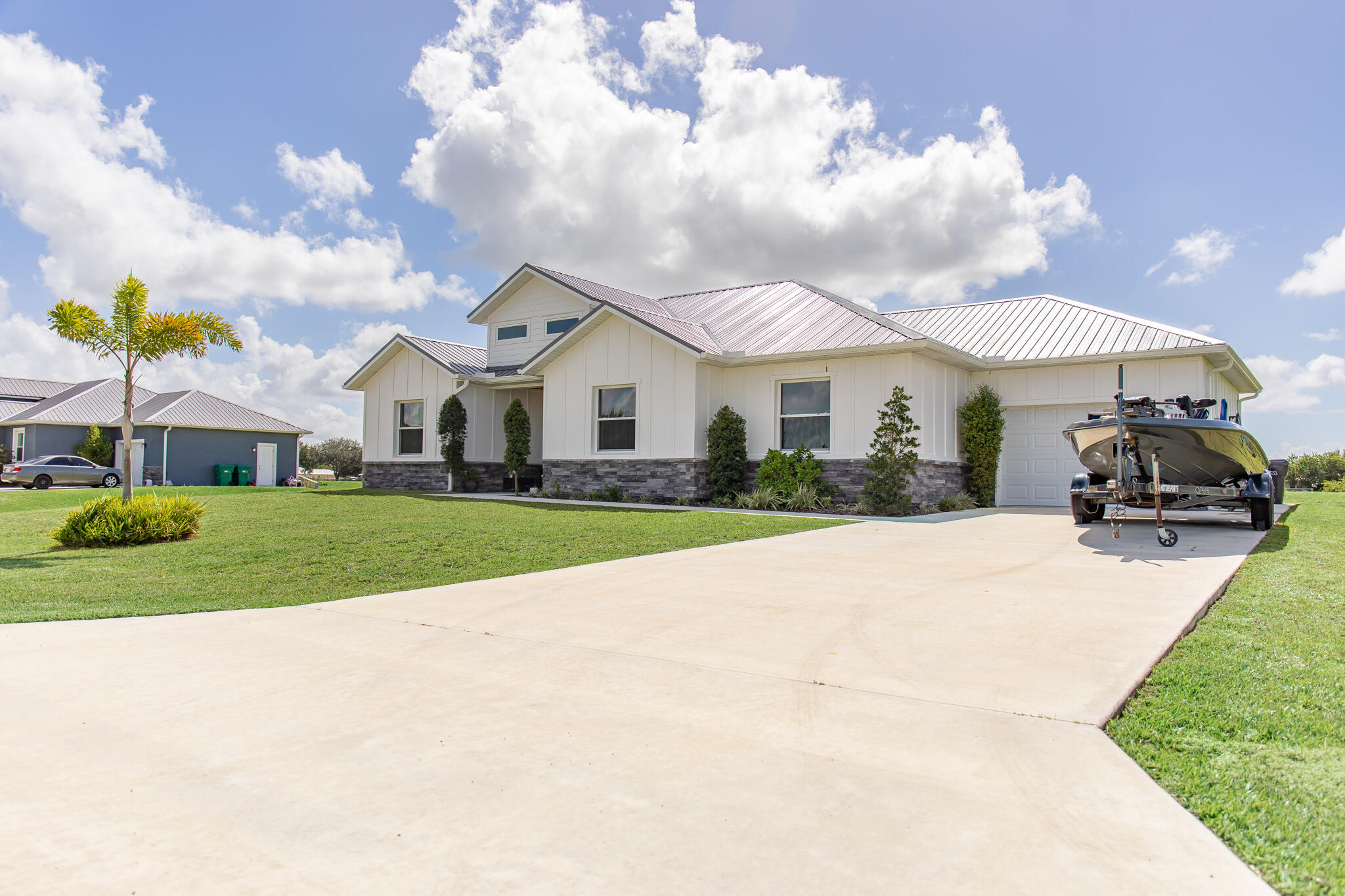 8640 Southwest 7th Lane Okeechobee, FL 34974 - Photo 34 of 52 a view of a white house with a big yard and potted plants