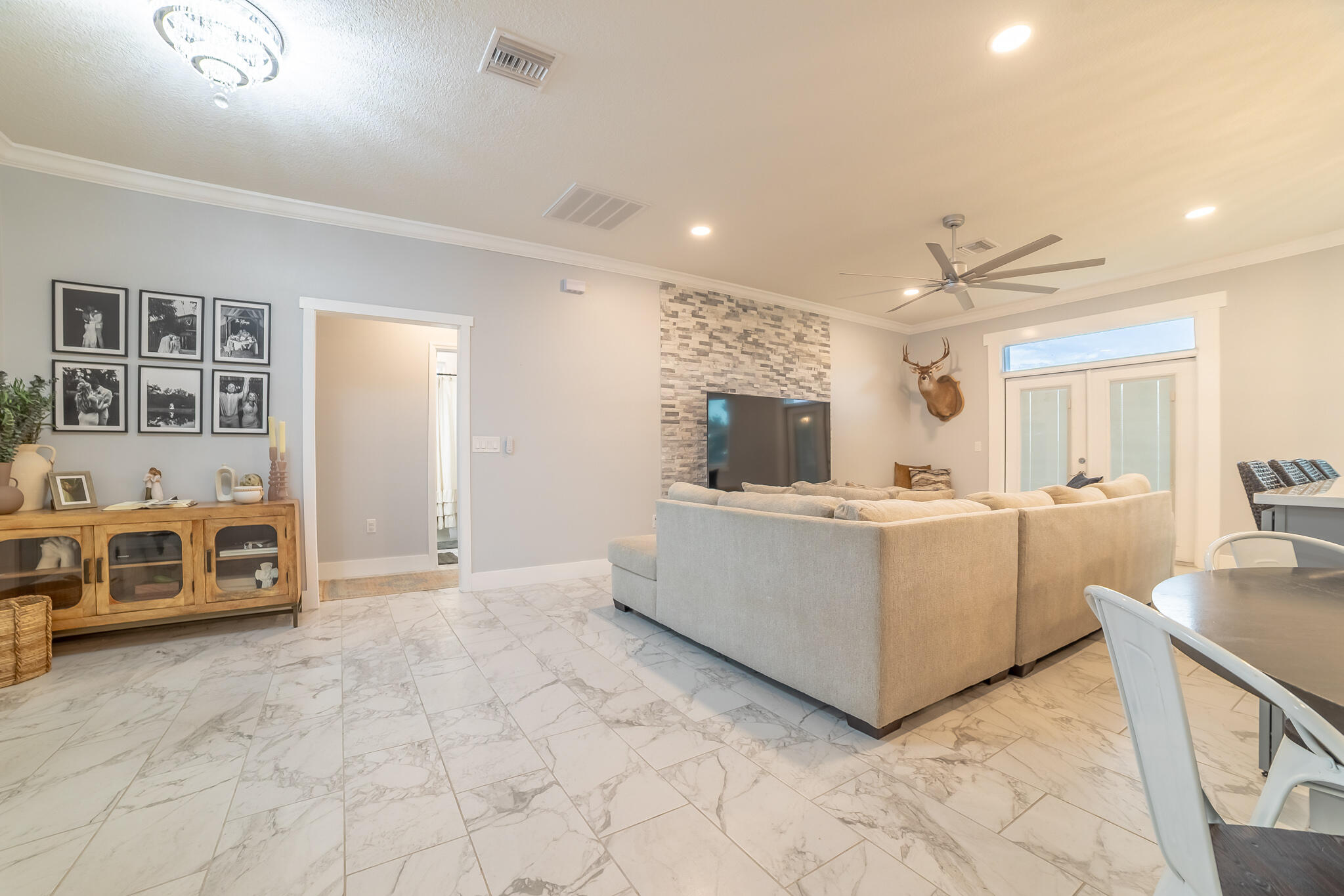8640 Southwest 7th Lane Okeechobee, FL 34974 - Photo 4 of 52 a large white kitchen with kitchen island a stove a sink a refrigerator and white cabinets with wooden floor