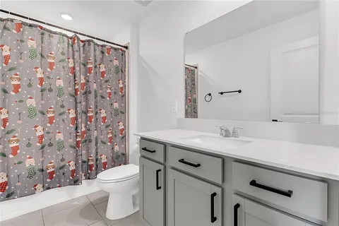 a bathroom with a granite countertop sink mirror vanity and toilet
