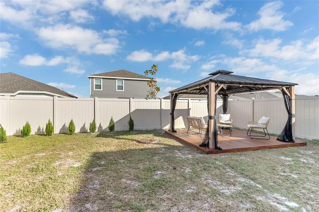 a view of a house with backyard and a tree