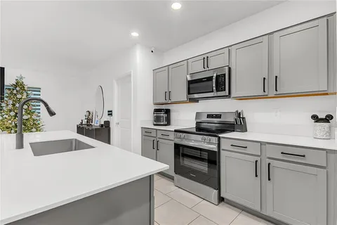 a kitchen with white cabinets stainless steel appliances and sink