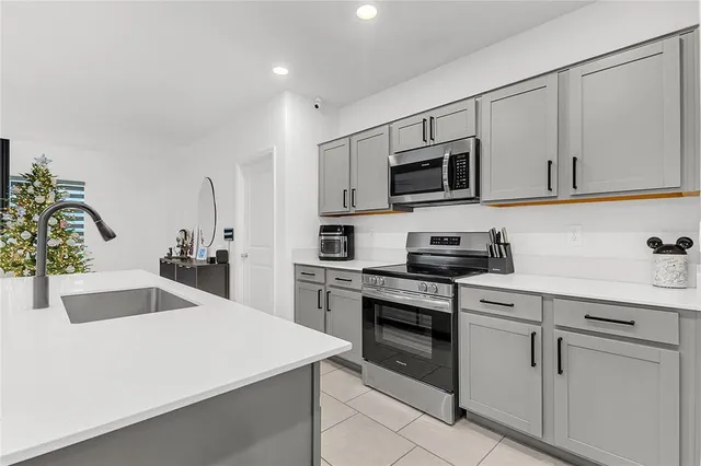 a kitchen with white cabinets stainless steel appliances and sink