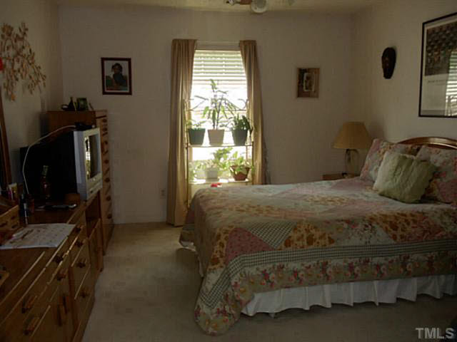 2315 Springhill Avenue Raleigh, NC 27603 - Photo 9 of 15 a bedroom with a bed and a flat tv screen on the dresser