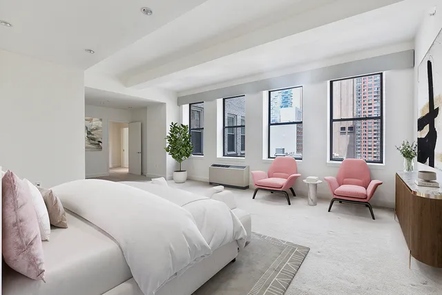 a spacious bedroom with a bed and large windows