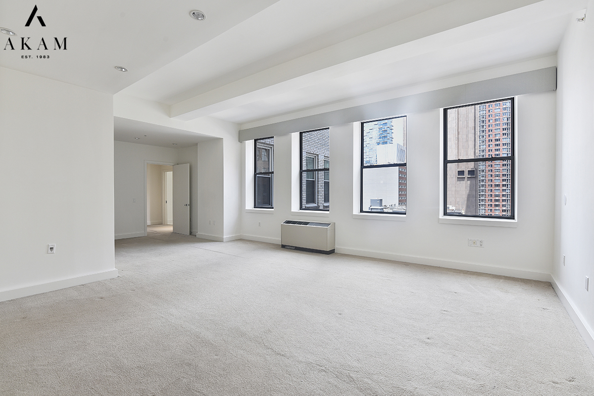 80 Chambers Street, Unit 10F Manhattan, NY 10007 - Photo 10 of 22 an empty room with windows and pillars in it