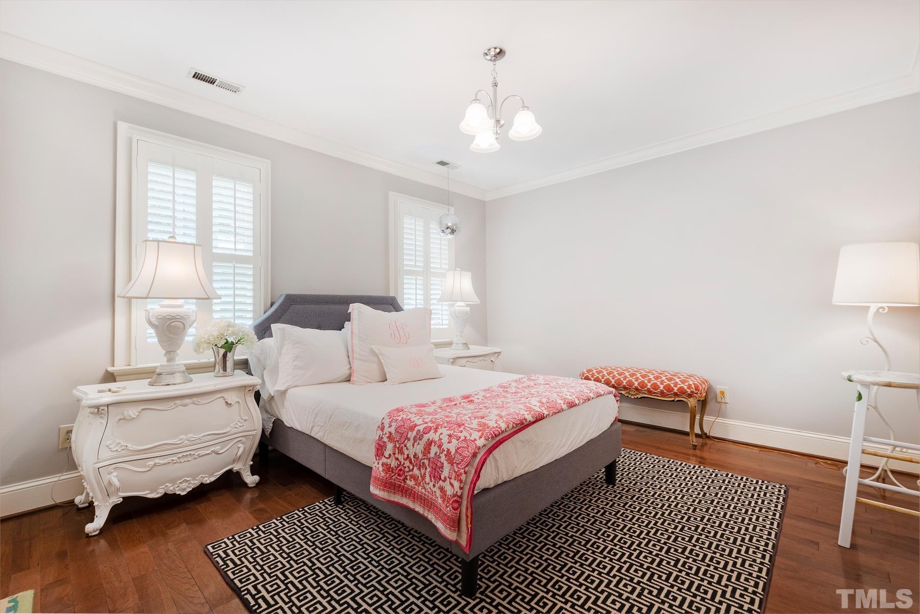 1430 Chester Road Raleigh, NC 27608 - Photo 24 of 39 a bedroom with a bed wooden floor and a lamp