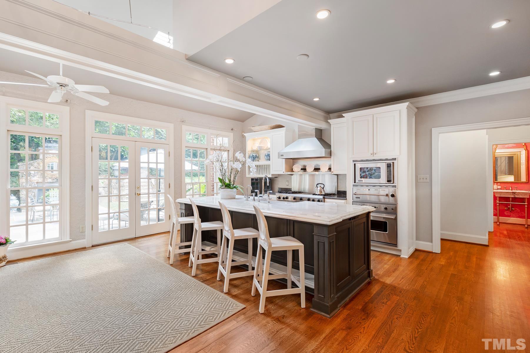 1430 Chester Road Raleigh, NC 27608 - Photo 10 of 39 a large kitchen with kitchen island a large counter top space a sink stainless steel appliances and cabinets