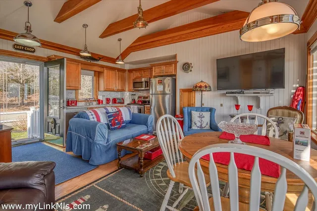 a living room with furniture a flat screen tv and a floor to ceiling window