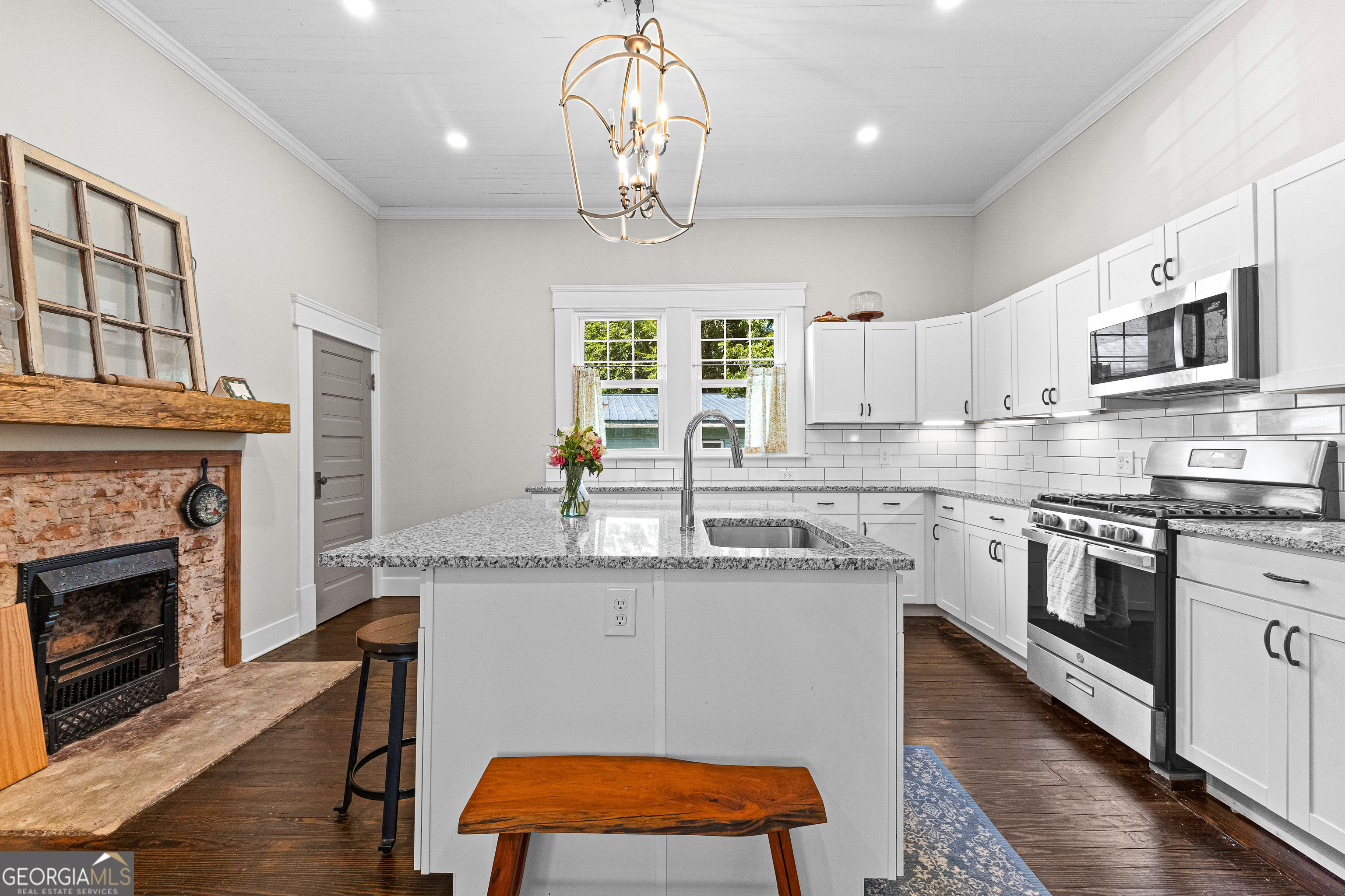 96 Griffin Street Grantville, GA 30220 - Photo 26 of 63 a kitchen with stainless steel appliances granite countertop a stove top oven a sink dishwasher and a fireplace with wooden floor
