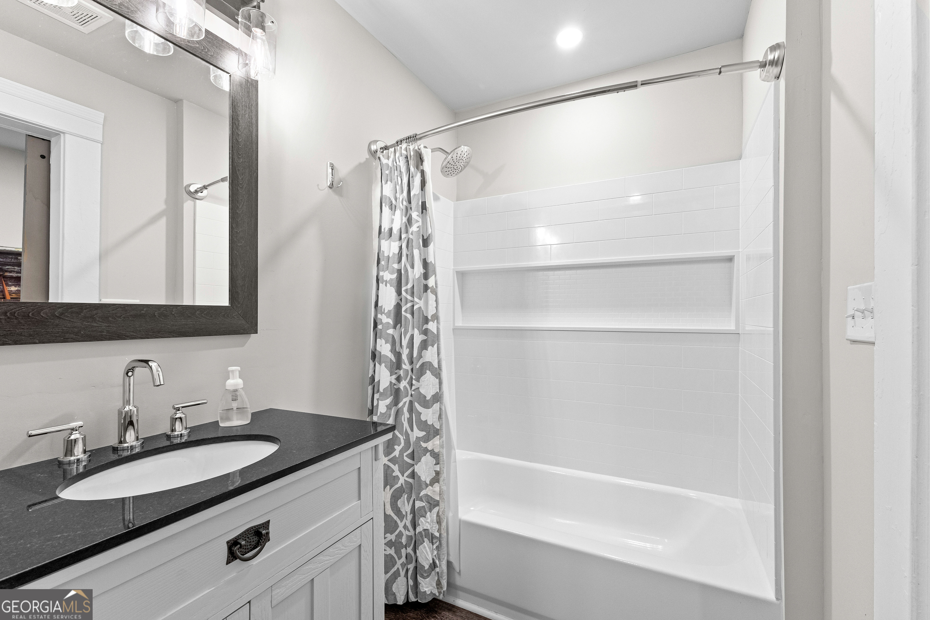 96 Griffin Street Grantville, GA 30220 - Photo 44 of 63 a bathroom with a granite countertop sink mirror and a bathtub