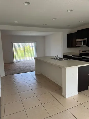 a kitchen with stainless steel appliances a sink a stove top oven a counter space and cabinets