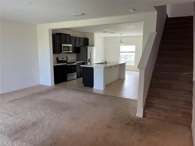 a view of kitchen with refrigerator stove microwave and cabinets