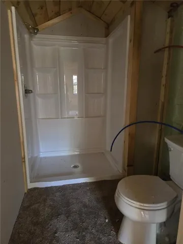 a bathroom with a toilet and a shower