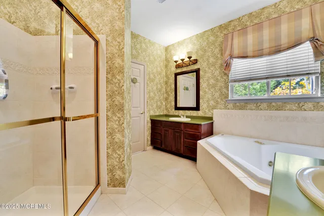 a bathroom with a tub a sink and mirror