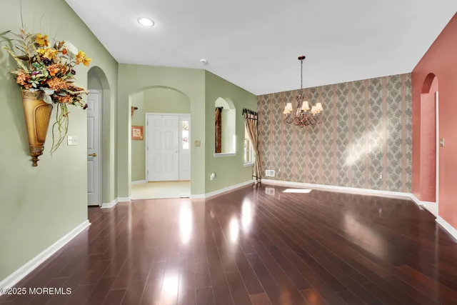 a view of a hallway with wooden floor and a living room