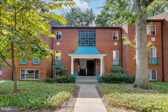 a front view of a house with yard and green space