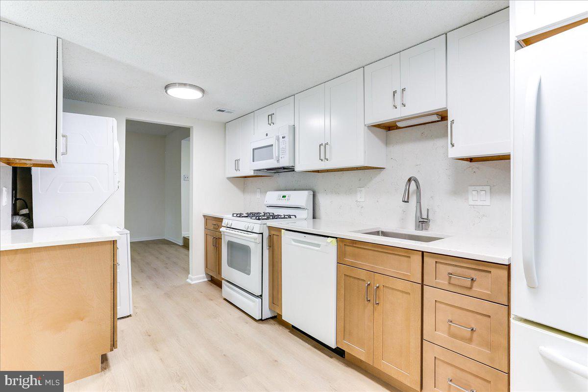 11823 Breton Court, Unit 2B Reston, VA 20191 - Photo 12 of 21 a kitchen with white cabinets and white appliances