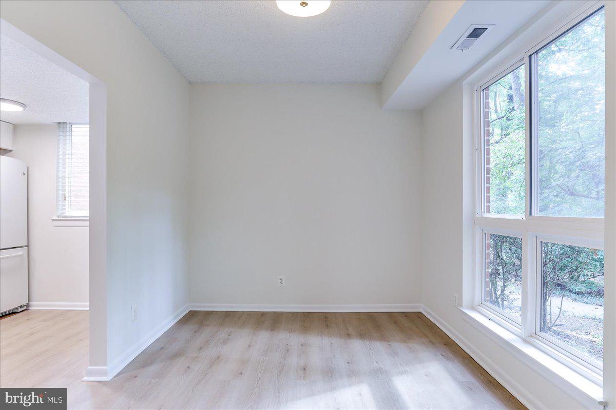 11823 Breton Court, Unit 2B Reston, VA 20191 - Photo 16 of 21 an empty room with wooden floor and windows