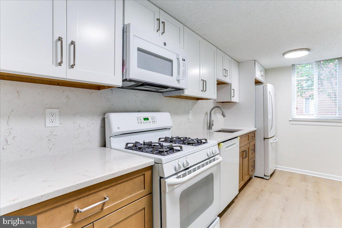 11823 Breton Court, Unit 2B Reston, VA 20191 - Photo 9 of 21 a kitchen with stainless steel appliances a white stove top oven and cabinets