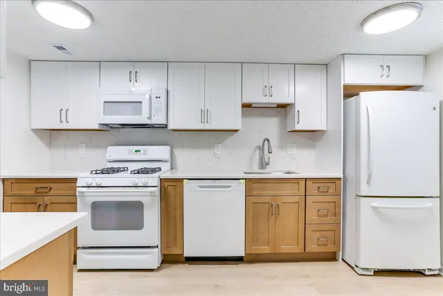 a kitchen with cabinets appliances and a sink
